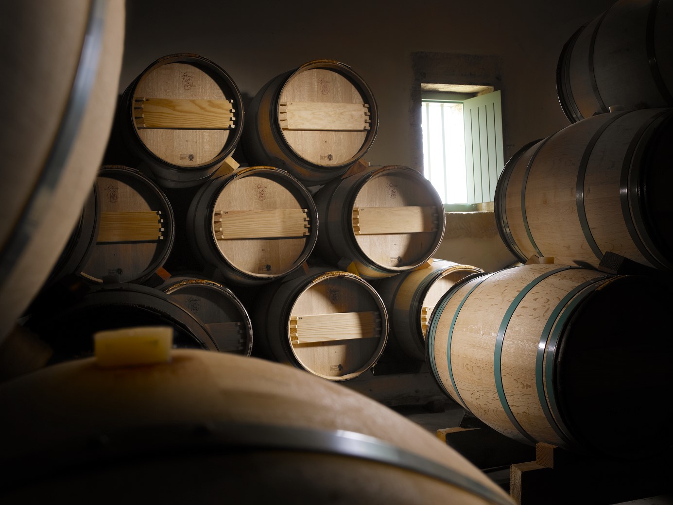 vue de plusieurs barriques neuves dans le chai pendant la phase d’elevage