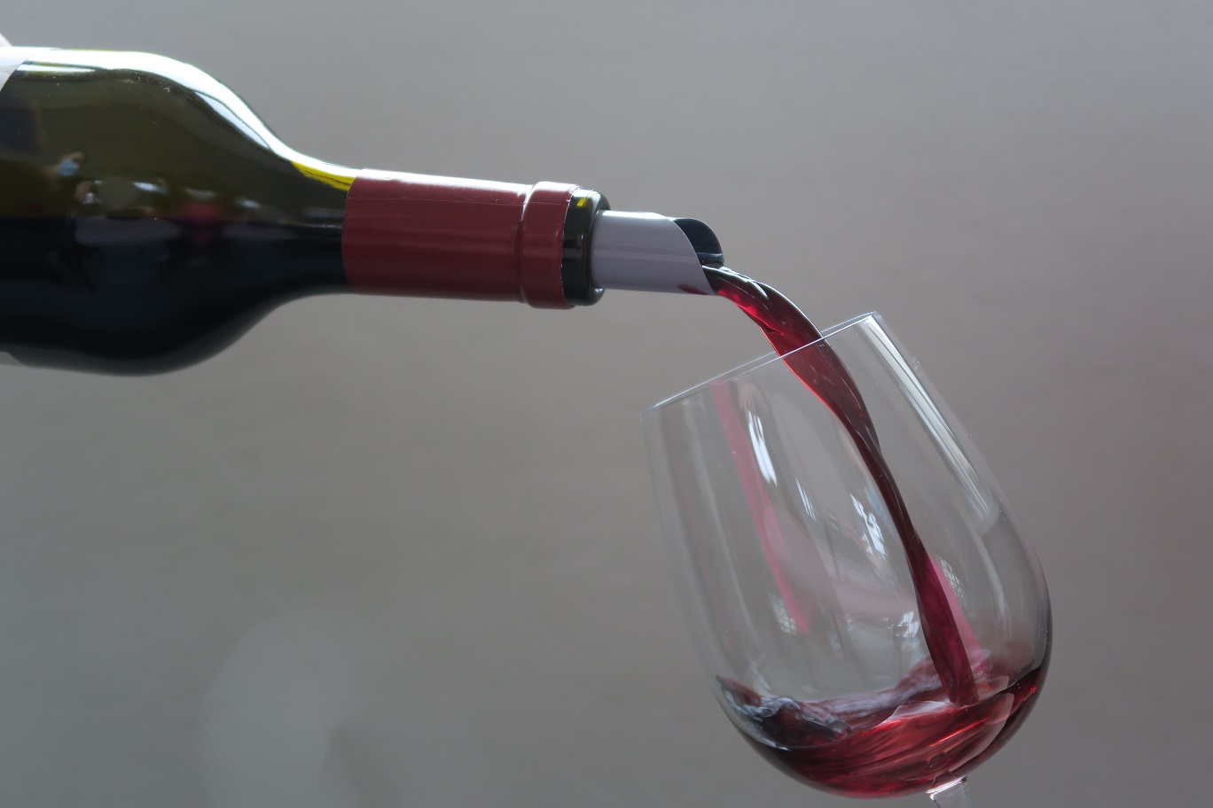 Une bouteille en train de remplir un verre de vin