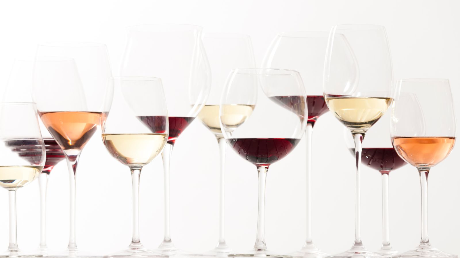 Verres à vins de différentes tailles et formes remplis de vin rouge, rosé et blanc